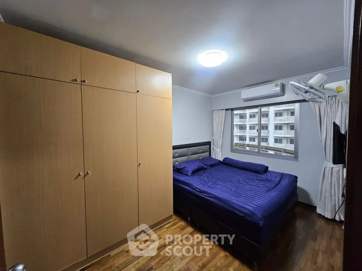 Cozy bedroom with wooden flooring and ample wardrobe space