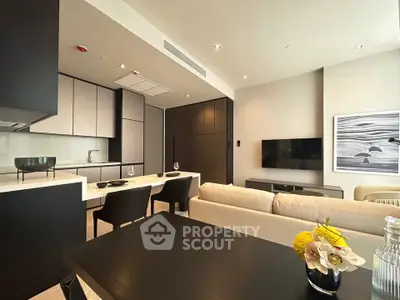 Modern open-layout living room with sleek kitchen, stylish furniture, and contemporary decor.