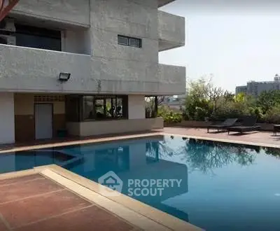 Luxurious apartment building with a serene outdoor pool and spacious deck area.