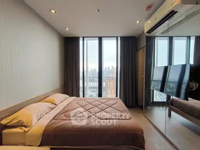 Modern bedroom with city view, featuring a cozy bed and mirrored wall for spacious feel.