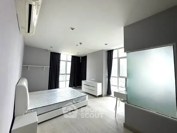 Spacious modern bedroom with large windows and minimalist design