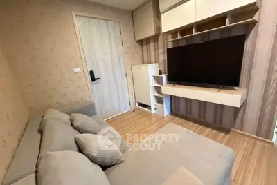 Cozy living room with modern decor and large TV, perfect for relaxation.