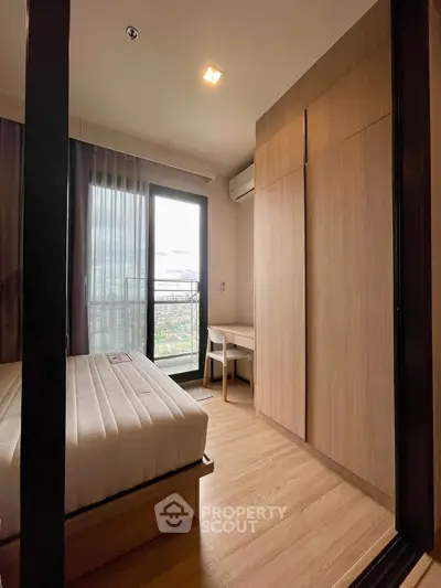 Modern bedroom with wooden flooring, large window, and built-in wardrobe.