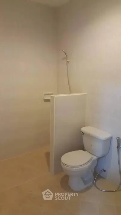Minimalist bathroom with toilet and shower in neutral tones