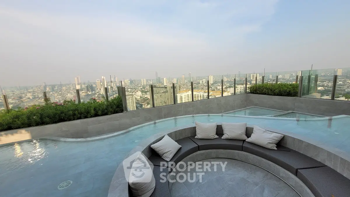 Luxurious rooftop pool with stunning city skyline view and modern seating area.
