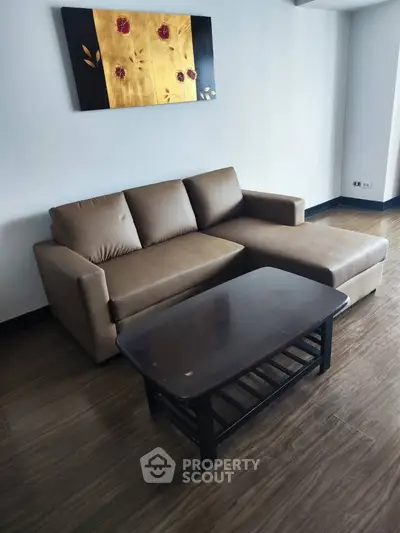Modern living room with stylish sofa and coffee table on wooden flooring.