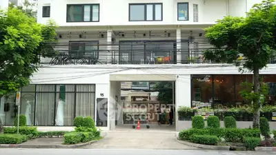 Modern building exterior with lush greenery and large windows