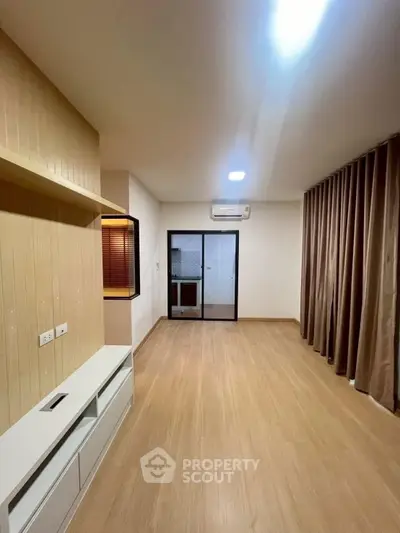 Spacious modern living room with wooden flooring and large window curtains