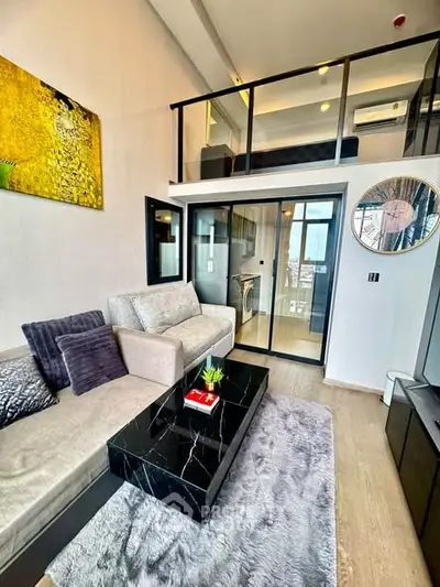 Modern loft-style living room with mezzanine, elegant decor, and stylish furniture in a contemporary apartment.