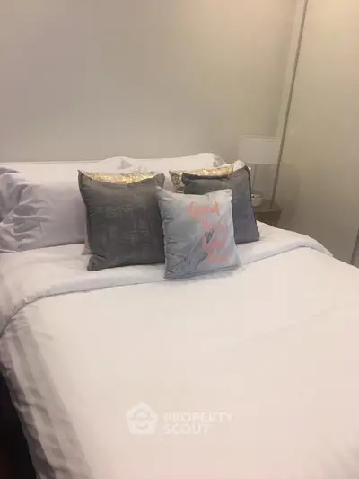 Cozy bedroom with stylish pillows and soft lighting, perfect for relaxation and comfort.
