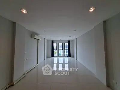 Spacious empty room with large windows and glossy tiled floor, perfect for customization.