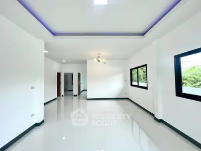 Spacious modern living room with large windows and sleek white flooring