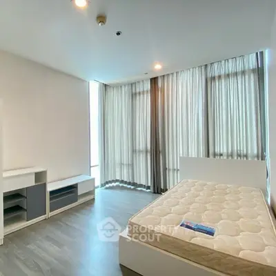 Spacious bedroom with large windows and modern furnishings