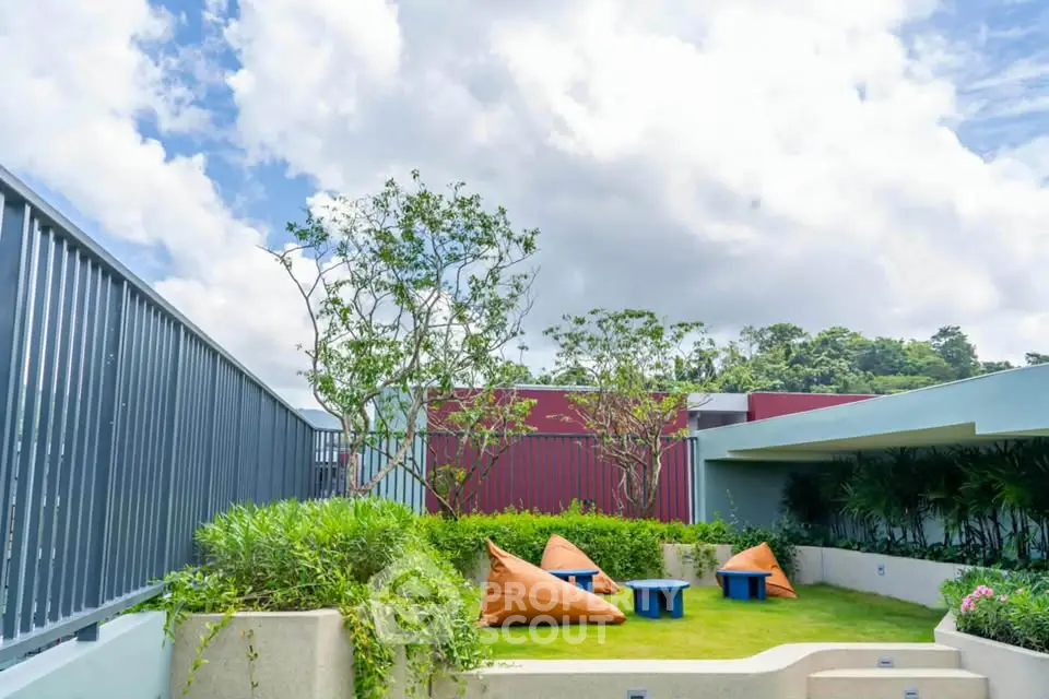 Stunning rooftop garden with lush greenery and cozy seating area under a bright blue sky.
