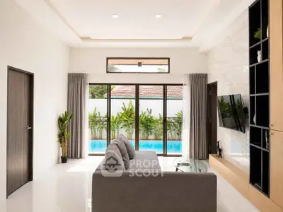 Modern living room with pool view, sleek furniture, and large windows for natural light.
