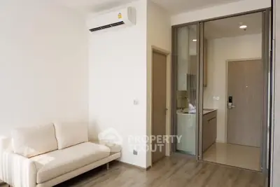Modern apartment interior with sleek kitchen and cozy living area, featuring minimalist design and neutral tones.
