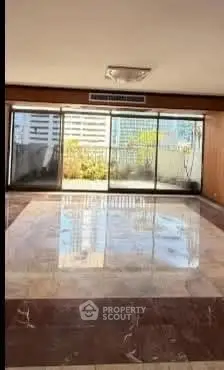Spacious living room with large windows and city view, perfect for modern urban living.