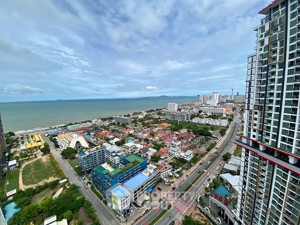Stunning high-rise view of coastal cityscape with ocean horizon and modern buildings.