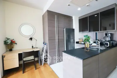 Modern kitchen with sleek cabinetry and integrated workspace, featuring stainless steel appliances and stylish decor.