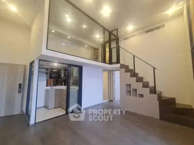 Spacious multi-level home with high ceilings, modern kitchen, and elegant staircase leading to an upper floor, perfect for luxurious urban living.