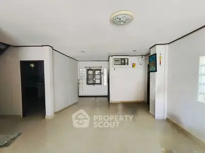 Spacious open-plan living area with tiled flooring and wall-mounted air conditioning.