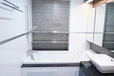 Modern bathroom with sleek bathtub and stylish tile design.