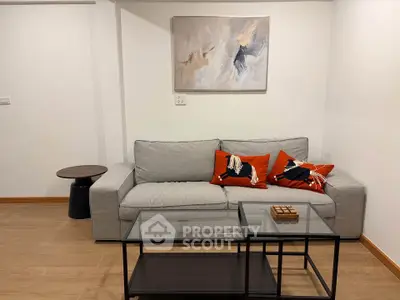 Modern living room with stylish gray sofa and abstract art on wall