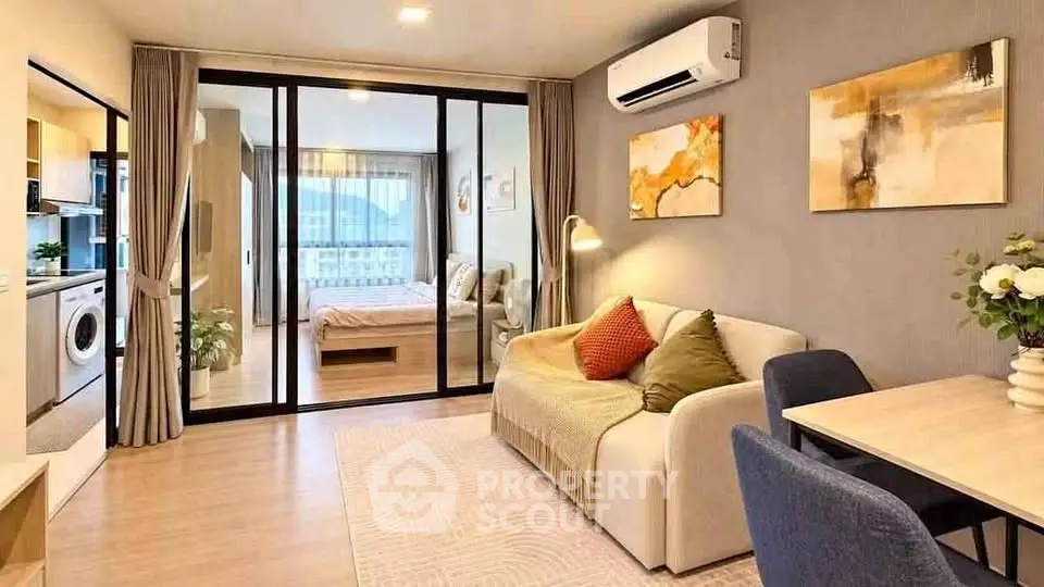 Modern apartment interior with cozy living room and bedroom separated by glass doors, featuring stylish decor.