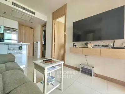 Modern living room with sleek TV setup and cozy seating area in a stylish apartment.