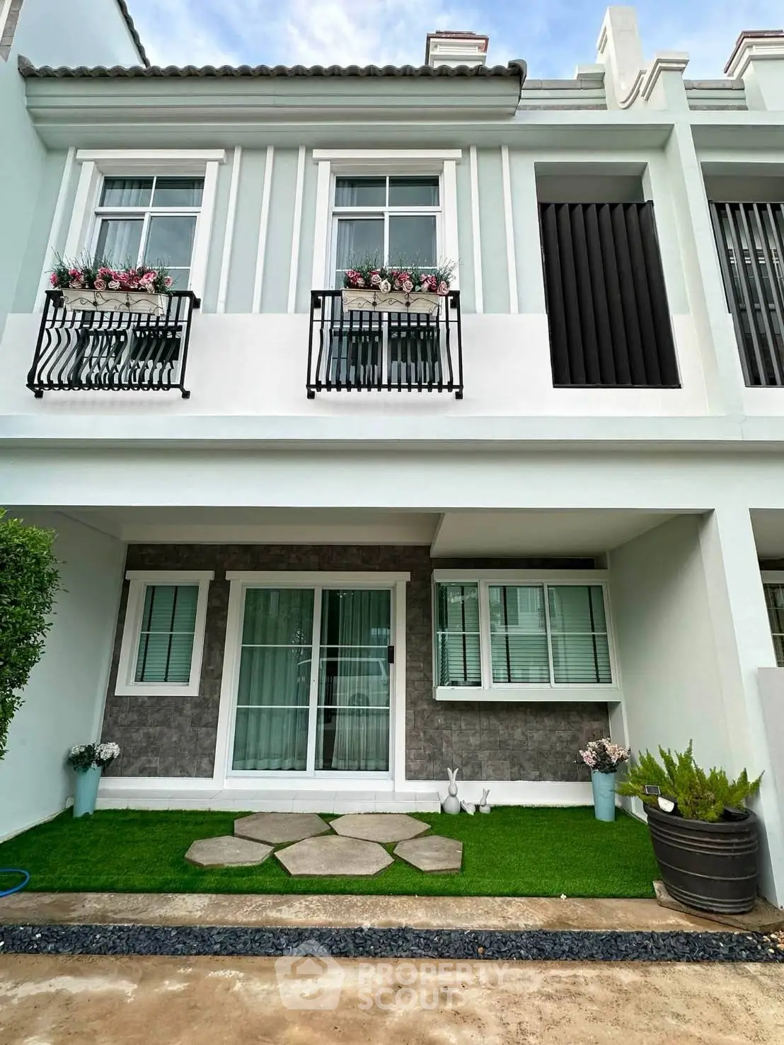 Charming townhouse exterior with flower-adorned balconies and modern design.