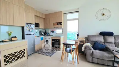 Modern open-plan kitchen and living room with city view, featuring sleek appliances and cozy seating.