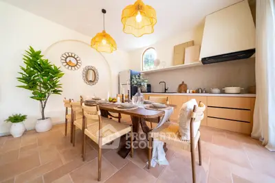 Charming dining area with natural light, stylish decor, and modern kitchen in open layout.