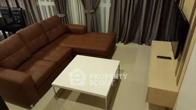 Modern living room with brown leather sofa and sleek white coffee table.