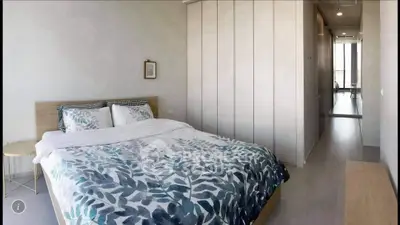 Spacious modern bedroom with stylish decor and ample natural light