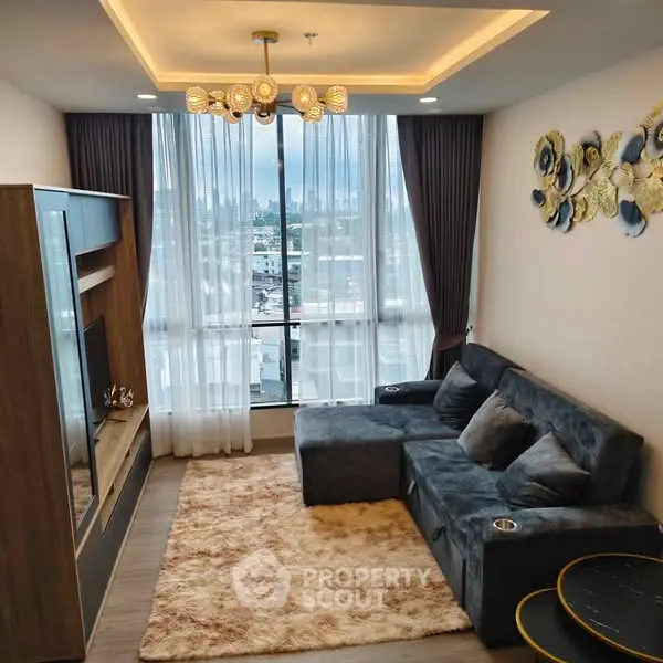 Stylish living room with modern decor and city view, featuring plush sofa and elegant lighting.
