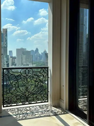 Luxurious balcony with ornate railing and stunning city skyline view.