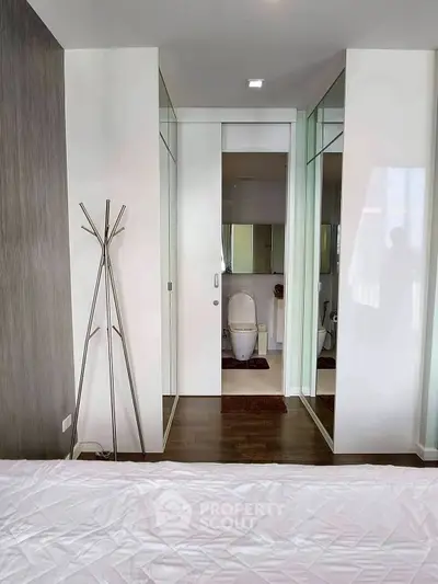 Modern bedroom with ensuite bathroom featuring sleek design and contemporary decor.