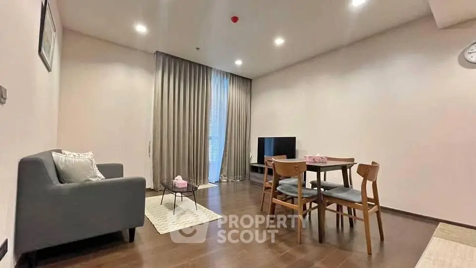 Modern living room with cozy seating and dining area, featuring elegant lighting and stylish decor.