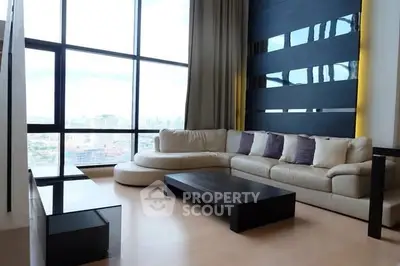 Luxurious living room with floor-to-ceiling windows and modern furniture offering stunning city views.