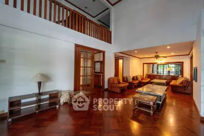 Spacious living room with elegant wooden flooring and cozy seating area.