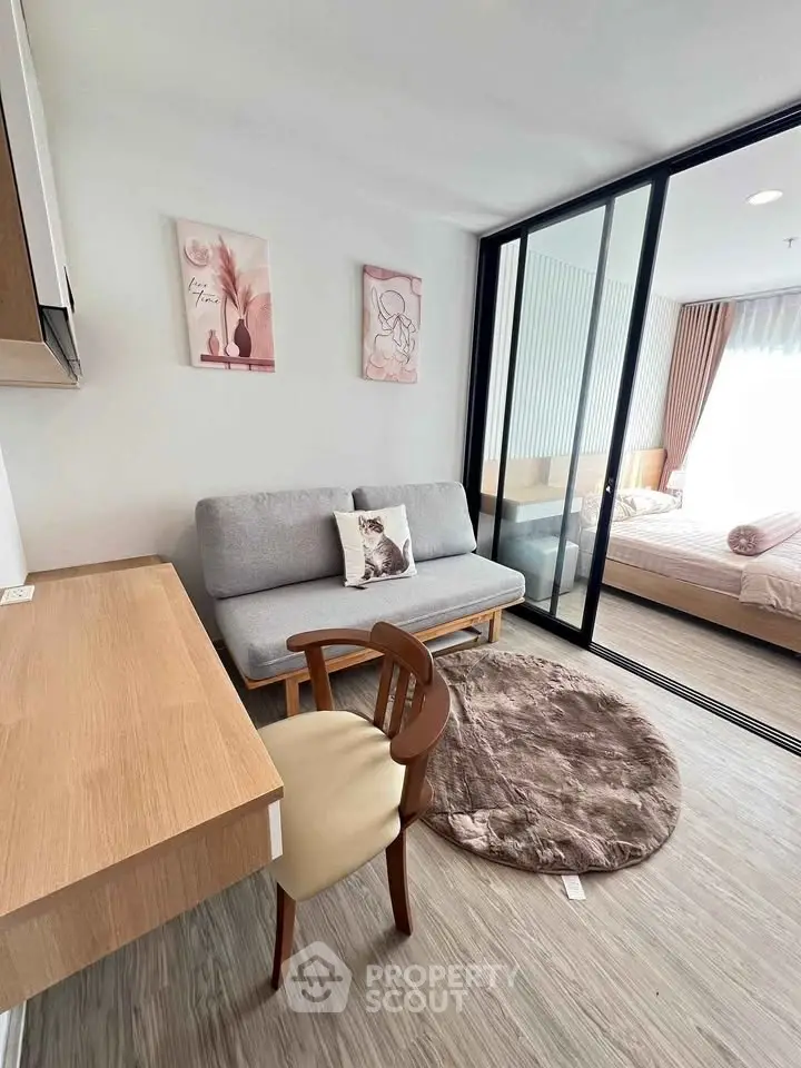 Modern living room with stylish decor and sliding glass doors leading to a cozy bedroom.