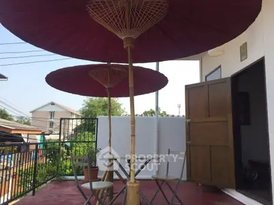 Charming balcony with traditional umbrellas and seating, perfect for relaxation.