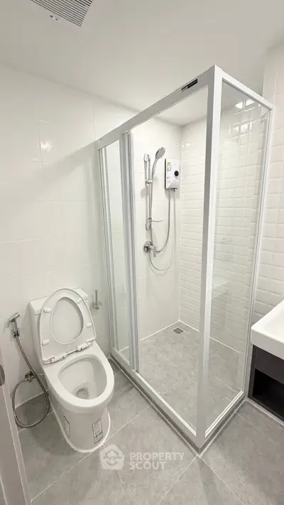 Modern bathroom with glass shower enclosure and sleek white fixtures