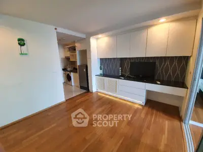 Modern living room with wooden flooring and built-in storage in a stylish apartment