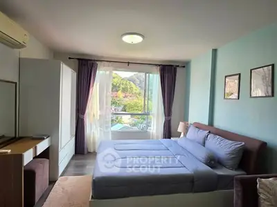 Spacious bedroom with scenic view, modern furnishings, and ample natural light.
