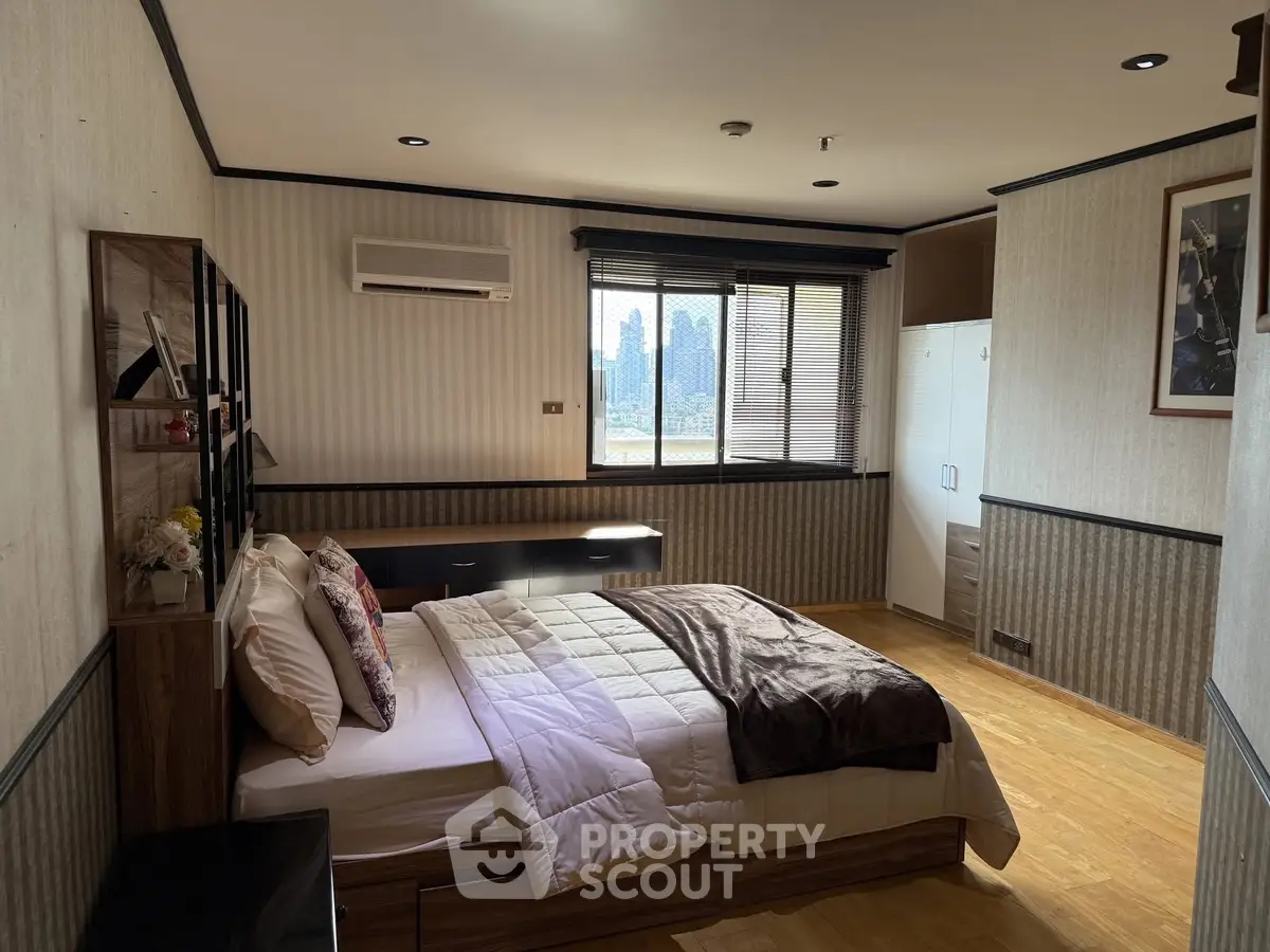 Spacious bedroom with city view, modern decor, and ample natural light.