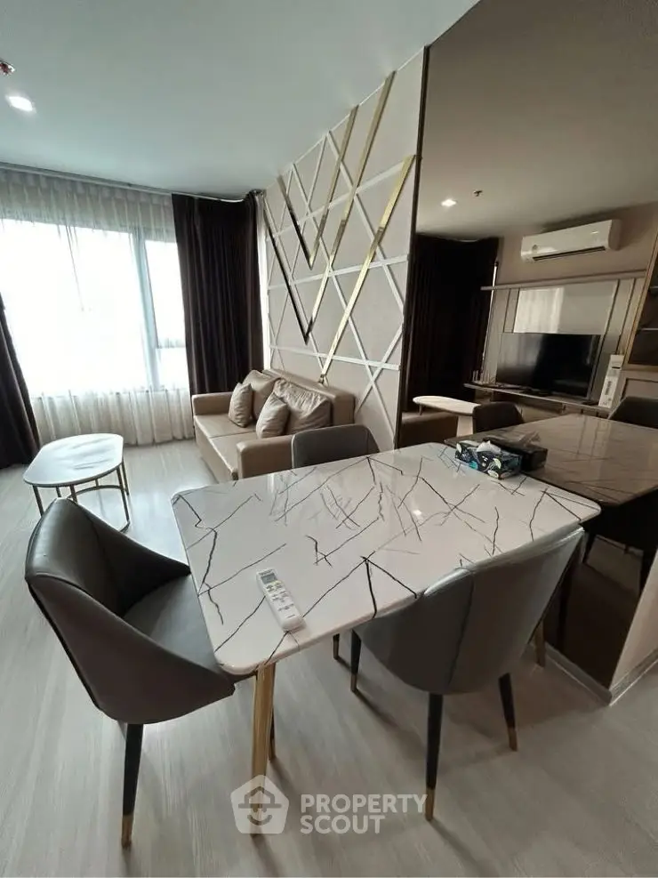 Modern living room with stylish decor and open layout, featuring a marble dining table and cozy seating area.