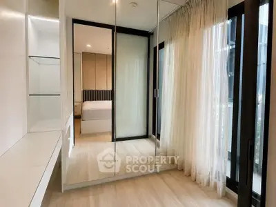 Modern bedroom with glass wardrobe and floor-to-ceiling windows in a stylish apartment.