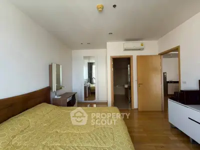 Spacious bedroom with modern furnishings and wooden flooring