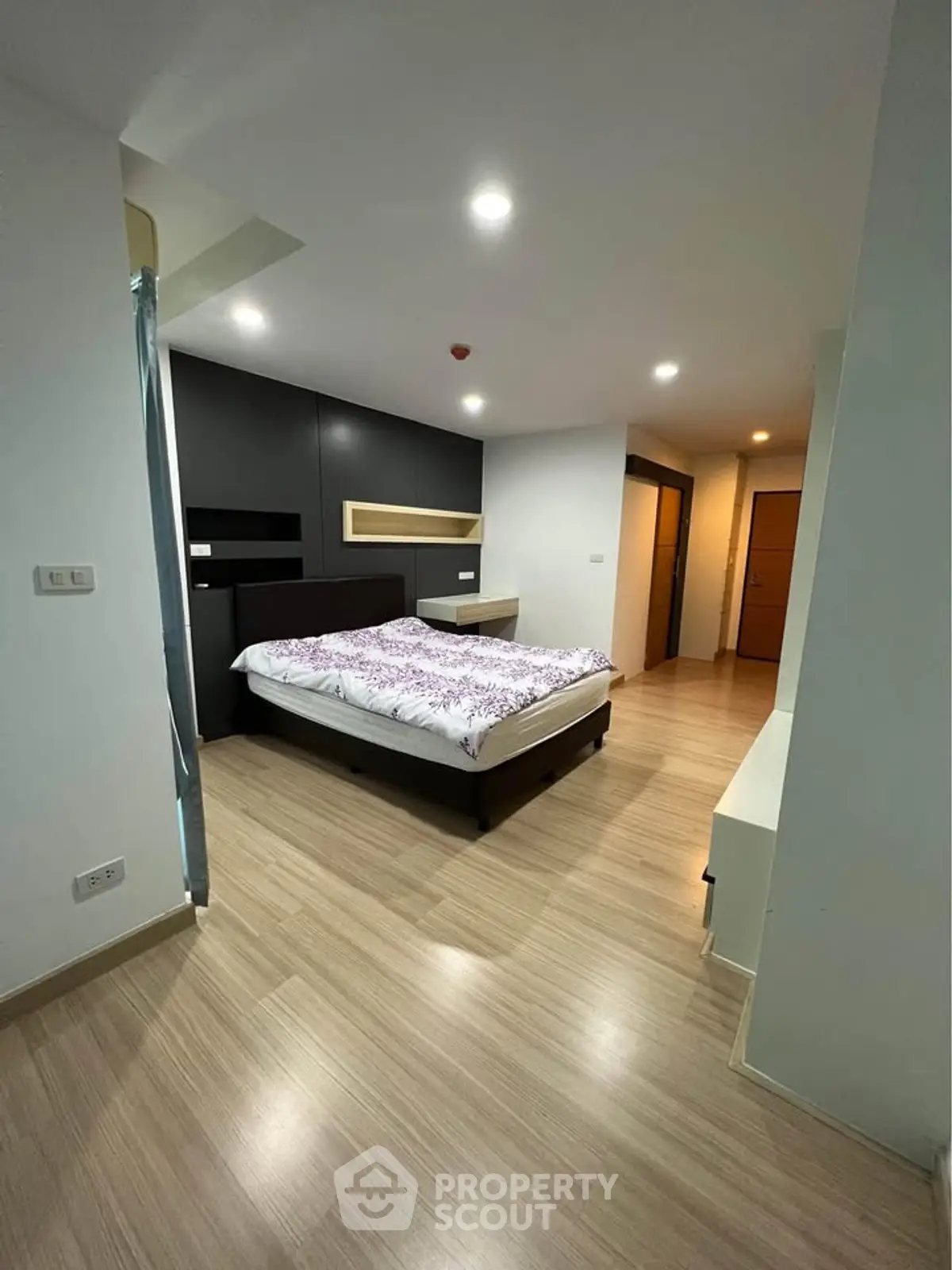 Spacious modern bedroom with wooden flooring and stylish decor